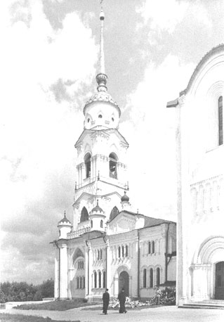 Westfacade; links klokkentoren en St. Joriskapel; twee monniken