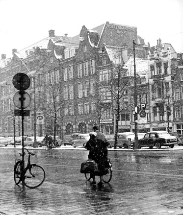 Fietsers en voetgangers in een besneeuwde straat