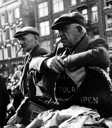 Twee mannen (met pet en sigaar) op de markt