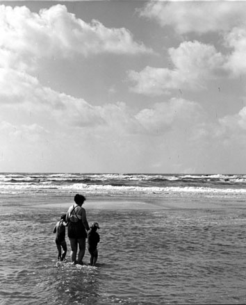 Uitzicht op zee, vrouw met twee kinderen op de voorgrond