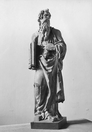 Mannenfiguur met lange baard, groot boek onder zijn rechterarm