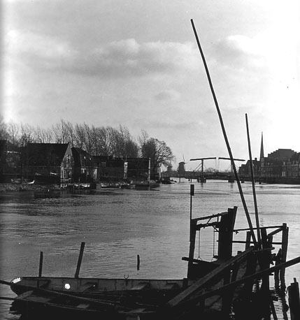 Zicht op stadje vanaf het water; op de achtergrond: ophaalbrug en molens