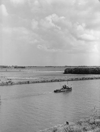 Vlak landschap, kanaal met boot op de voorgrond