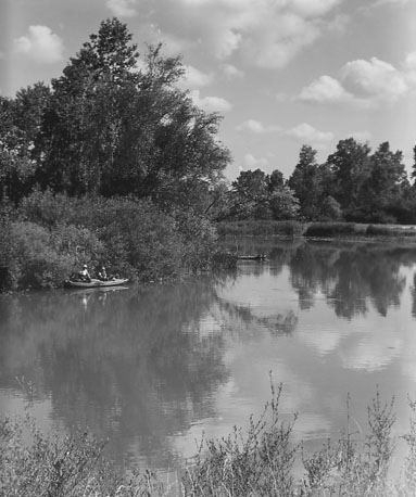 Landschap met bomen, water (ven?) en bootje met twee mensen in rietkraag