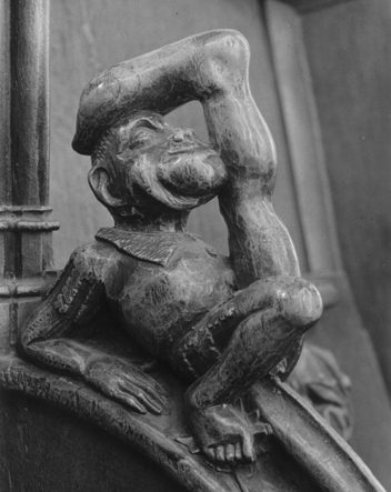 Koorbanken, detail: knop met een fantasiewezen liggend op zijn rug met een grote voet boven zijn hoofd (sciapode)