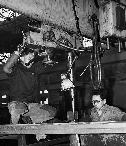 Twee arbeiders met hydraulische boor